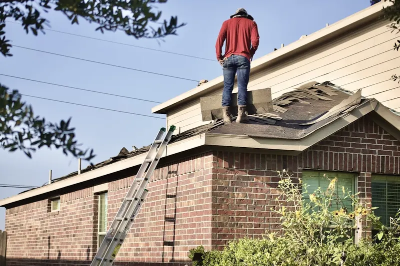Professional roofer working on a residential roof in Miller